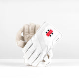 The Gray Nicolls Classic Prestige WK Gloves 2026 feature padded fingers for impact protection and a red and black logo on the wrist. This white pair is displayed upright on a white surface with a plain white background.