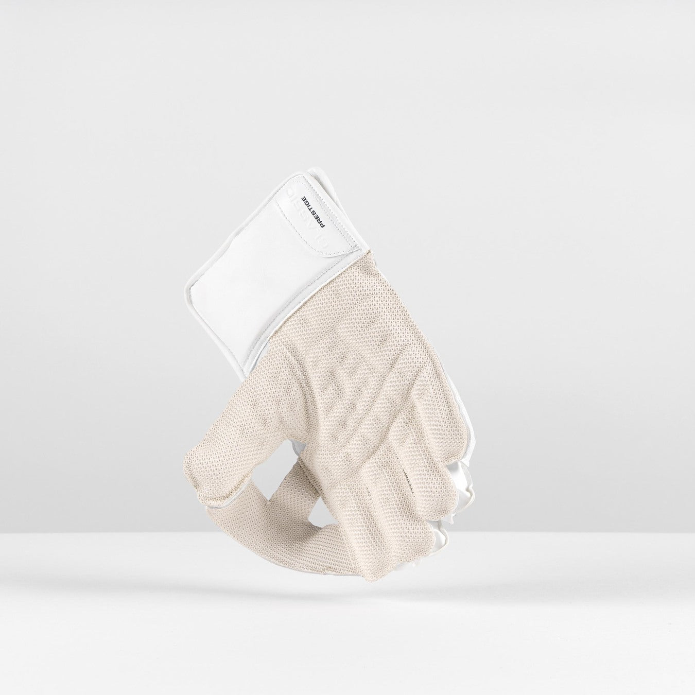 The Gray Nicolls Classic Prestige WK Gloves 2026 stand upright on a white surface, featuring a beige knit design with a white cuff and Velcro closure, and provide dependable impact protection against a plain white background.