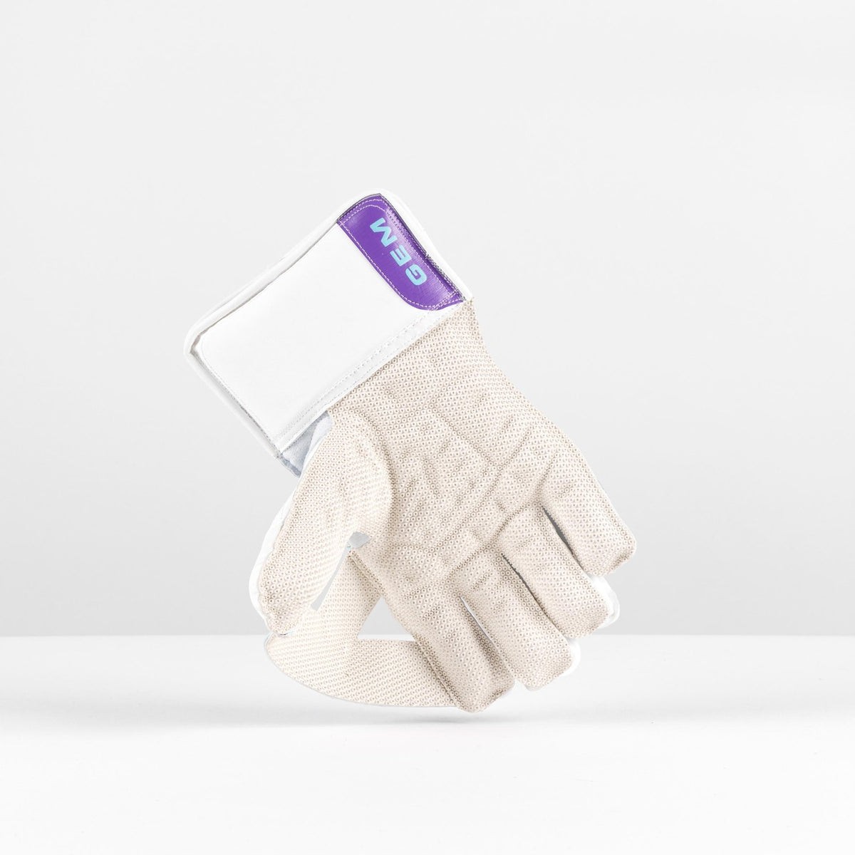 A pair of Gray Nicolls Classic GEM WK Gloves 2026 in beige with a white wrist strap and purple GEMA label, shown upright against a plain white background.