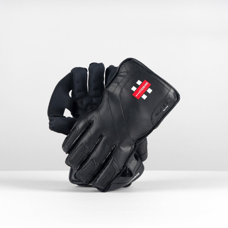 The Gray Nicolls Classic Elite WK Glove 2026 by Gray Nicolls is displayed upright on a white surface against a plain, light background, showing its classic design and superior comfort.
