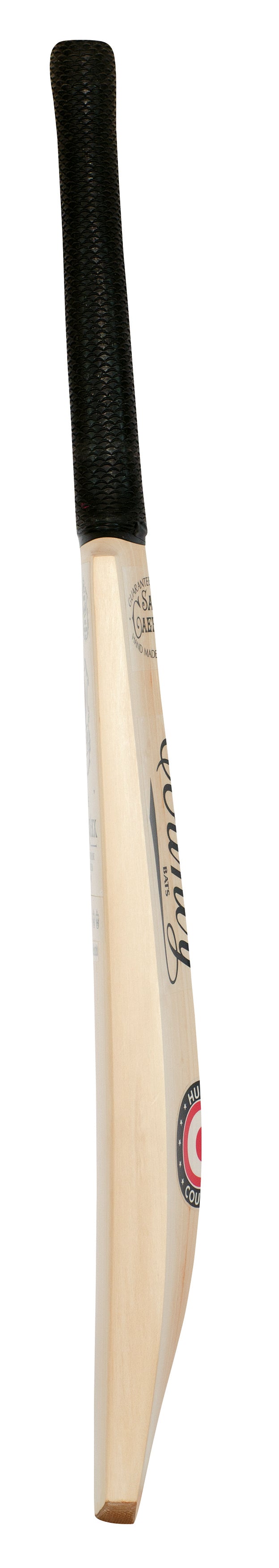 The Hunts County Caerulex Senior Cricket Bat features a traditional shape, black textured grip, and visible branding on the blade. Made from Grade 1 English Willow, it's a premium choice from Hunts County for senior players.