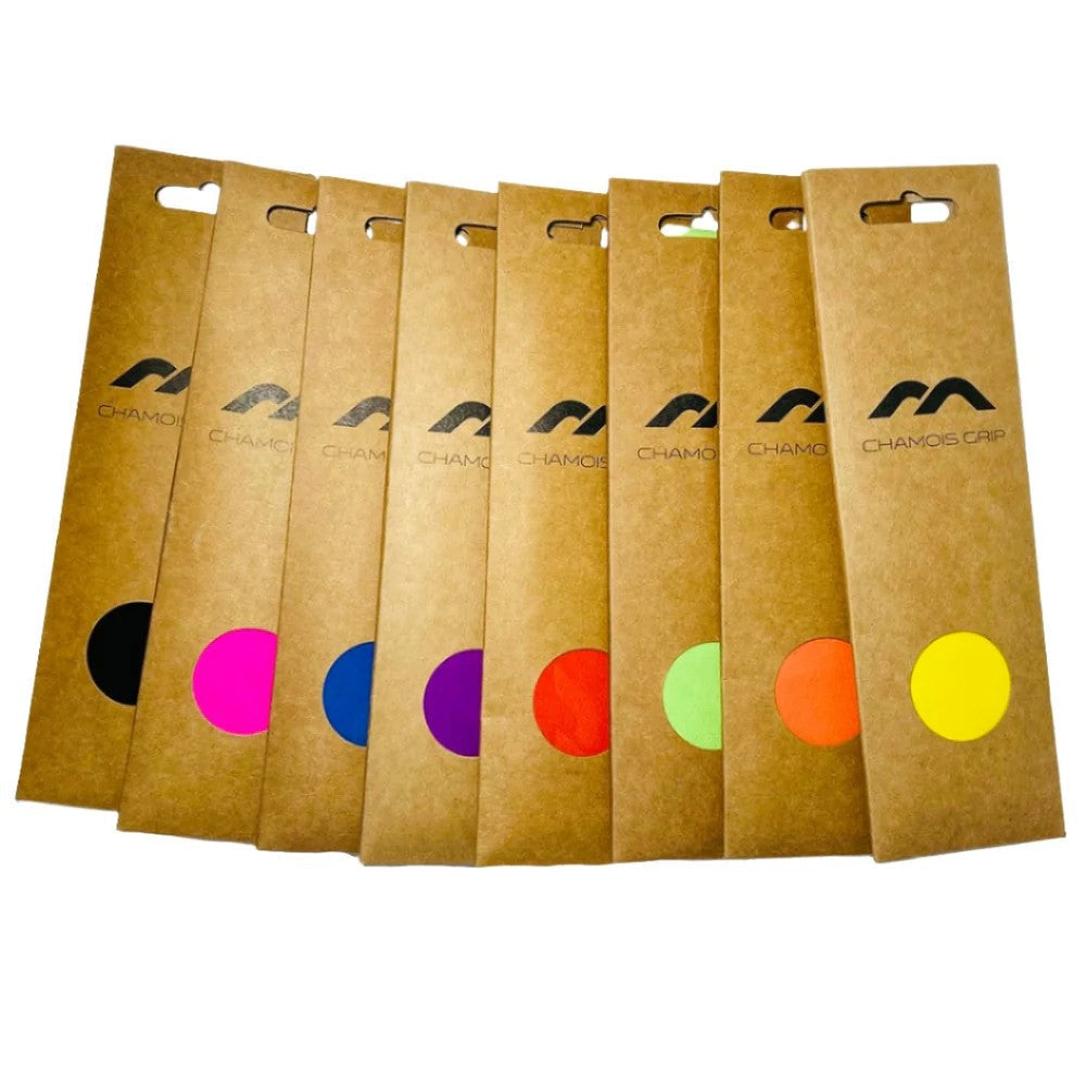 Ten brown Mercian Chamois Hockey Grip packages are arranged in a row, each with a different colored circle and the Mercian logo—ideal for any chamois hockey grip or hockey stick grip enthusiast.