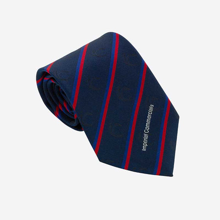 A Custom Club & School Tie by Martin Berrill Sports, navy blue with diagonal red and light blue stripes and "Imperial Commercials" on the front, is shown against a plain white background.