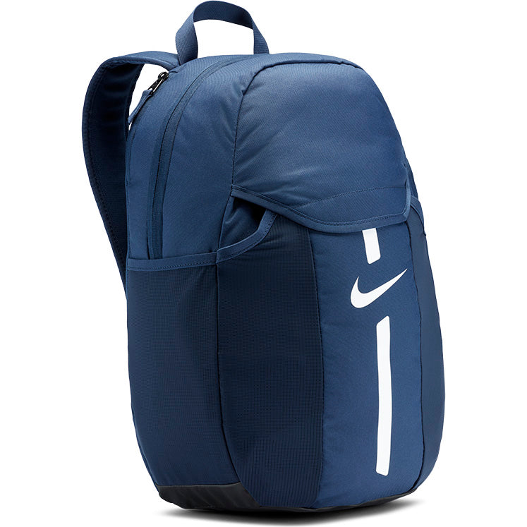 The Nike Academy Team Backpack Junior in Navy/White features a top zipper, side pockets, white Nike swoosh logo, handle, adjustable shoulder straps, breathable design, and Storm-FIT rain protection.