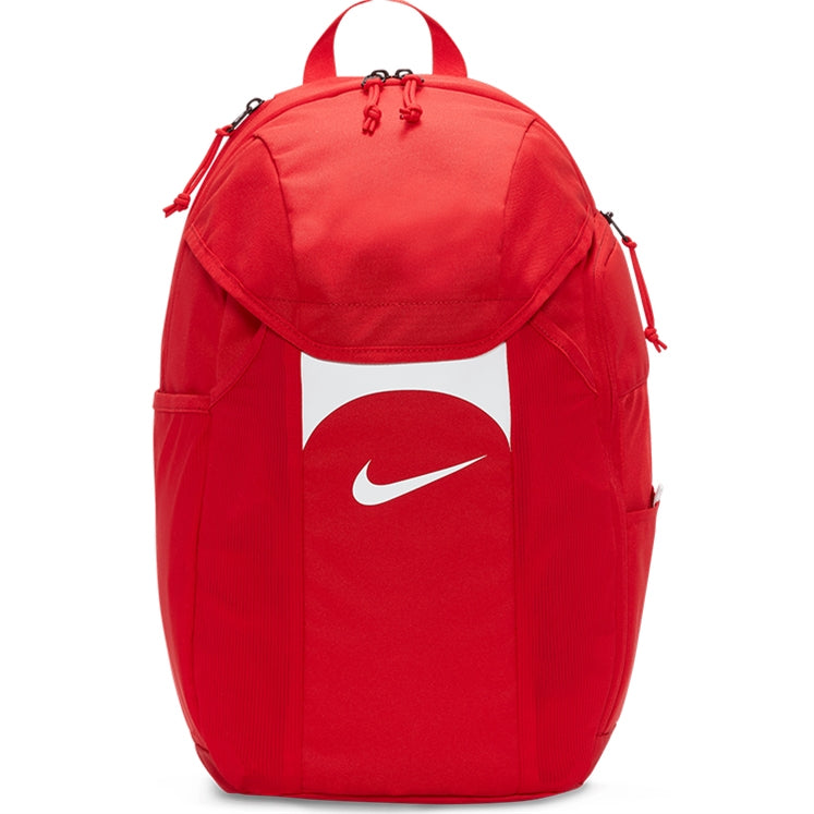 The Nike Academy Team Backpack in Red/White features Storm-FIT rain protection, a white swoosh logo, top handle, side pockets, and zippered compartments.