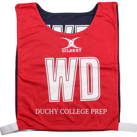 Introducing the Personalised Gilbert Netball Bibs (Reversible) by Gilbert—a red sports bib featuring the iconic GILBERT logo, bold white WD letters, and “DUCHY COLLEGE PREP” printed along the bottom. Designed with black sides and adjustable white straps for a comfortable fit, this reversible bib is an excellent choice for school netball teams looking for top-quality netball gear.