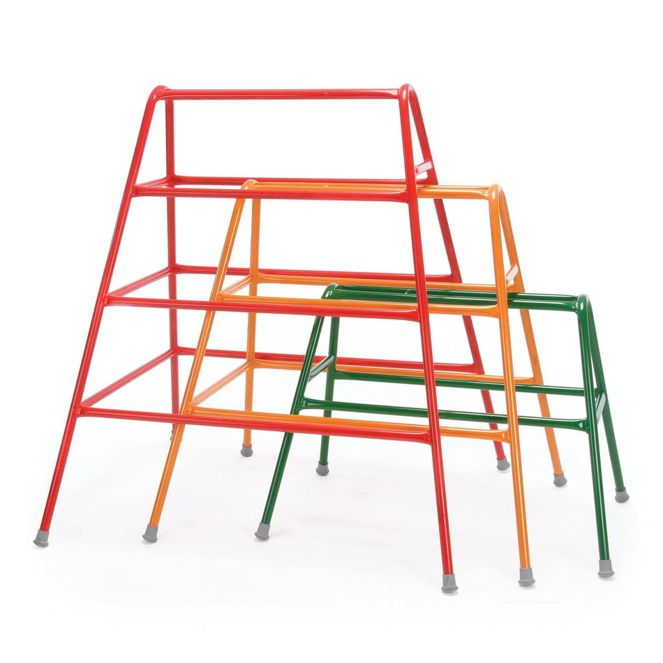 Three Niels Larsen Agility Trestles by Niels Larsen in red, orange, and green A-frame designs nest together. Made from powder-coated steel with non-marking rubber feet, they’re shown standing on a white background.
