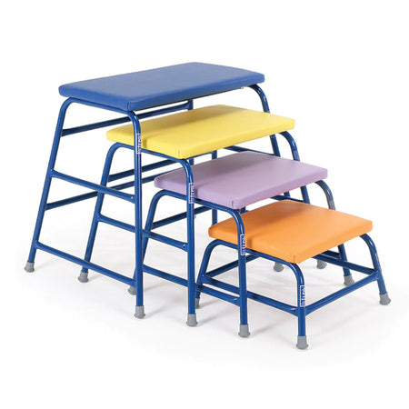 The Niels Larsen Agility Table set by Niels Larsen includes four platforms with powder-coated steel frames and colorful tops—blue, yellow, purple, and orange—each with a foam padded surface, arranged from shortest to tallest.