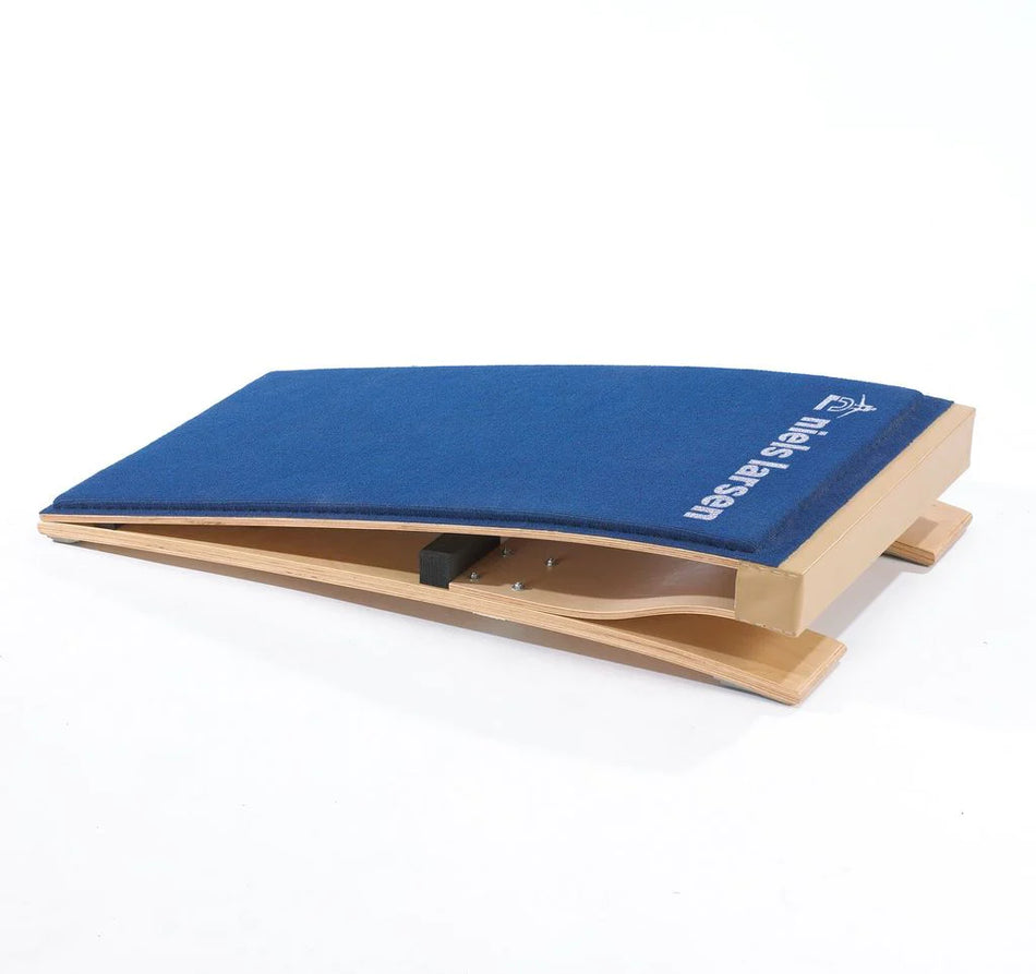 The Niels Larsen Club Springboard by Niels Larsen is a blue, wooden Reuther-style springboard with a padded carpet top and sturdy base, slightly curved for vaulting exercises.