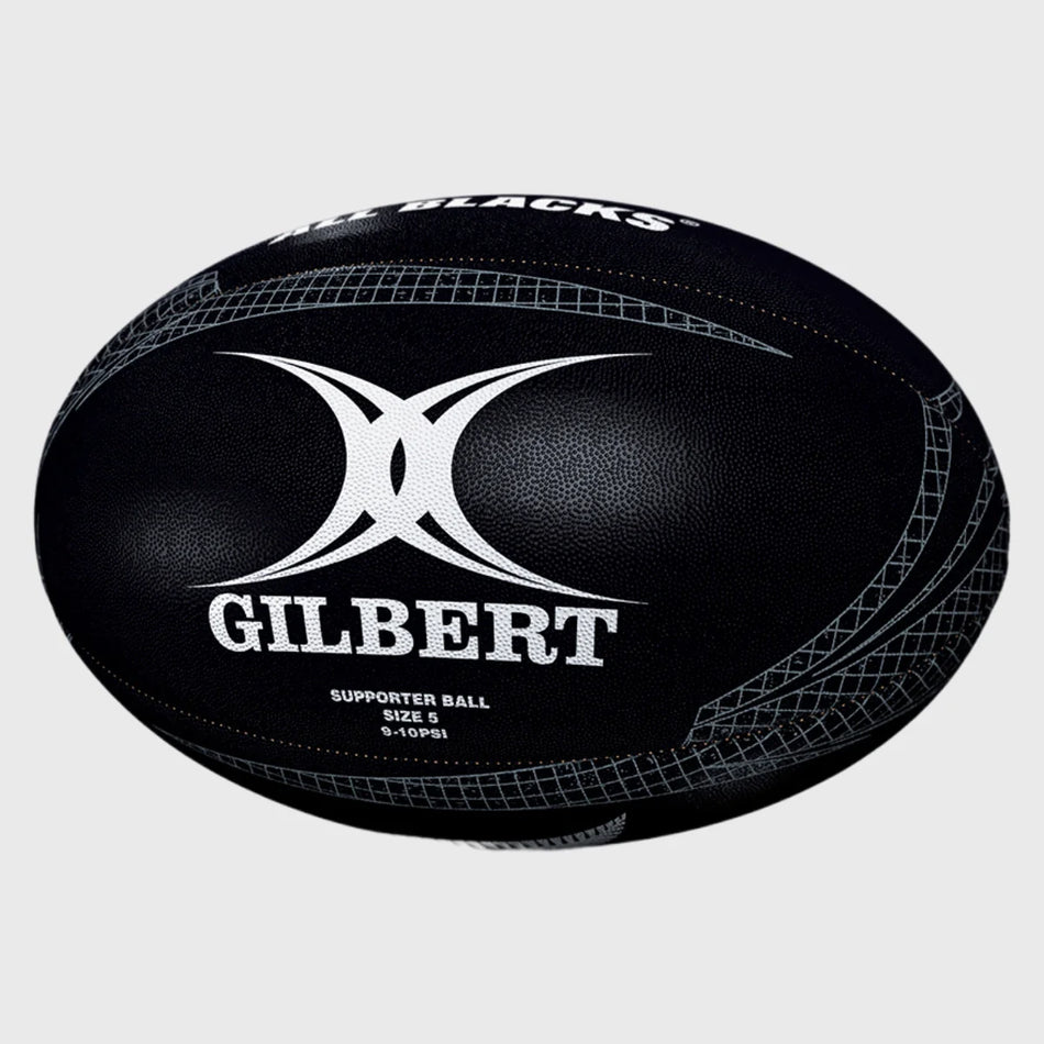 The Gilbert All Blacks Supporter Rugby Ball Size 5 by Gilbert features black and white detailing, the GILBERT logo, and displays "SUPPORTER BALL SIZE 5" and "ALL BLACKS," making it ideal for New Zealand rugby fans.