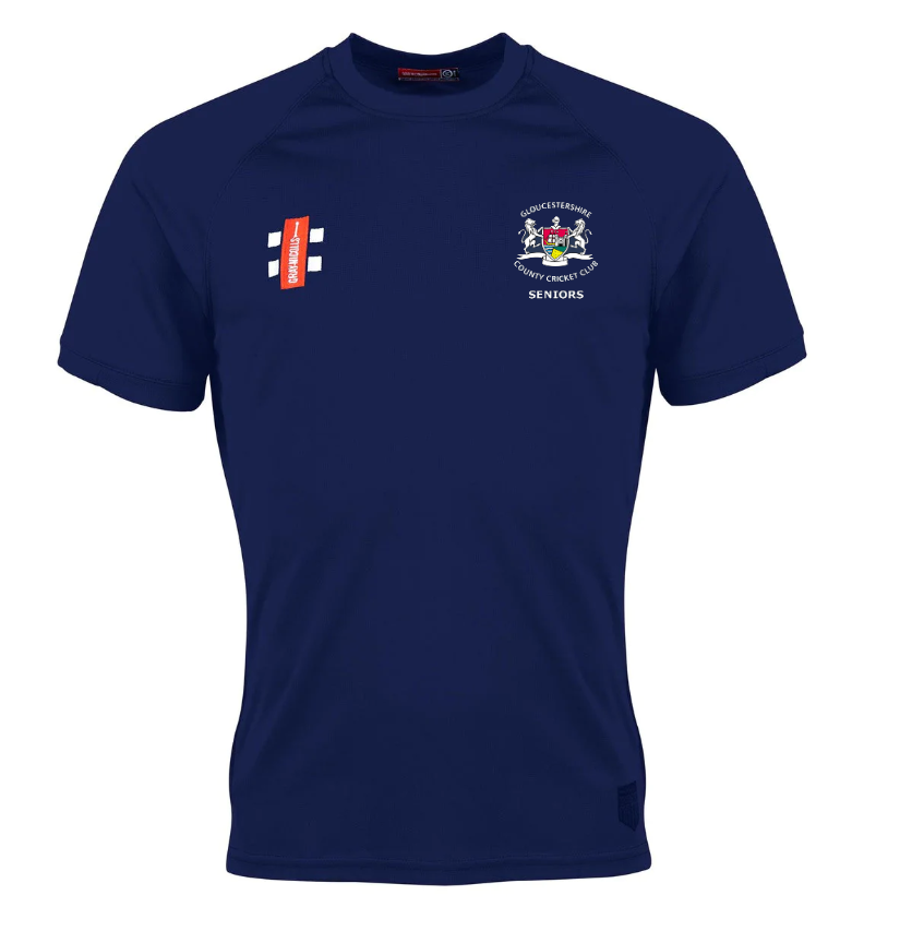 The Gray Nicolls Gloucestershire CCC Seniors Matrix V2 T-Shirt is navy blue with a white crest and "Gloucestershire Seniors CCC" on the left chest, advanced moisture management, and a red sponsor logo with white text on the right chest.