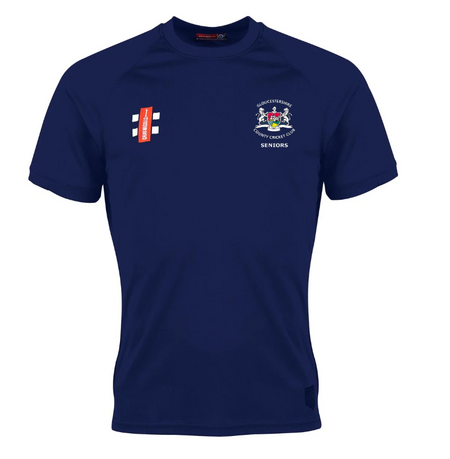 The Gray Nicolls Gloucestershire CCC Seniors Matrix V2 T-Shirt is navy blue with a white crest and "Gloucestershire Seniors CCC" on the left chest, advanced moisture management, and a red sponsor logo with white text on the right chest.