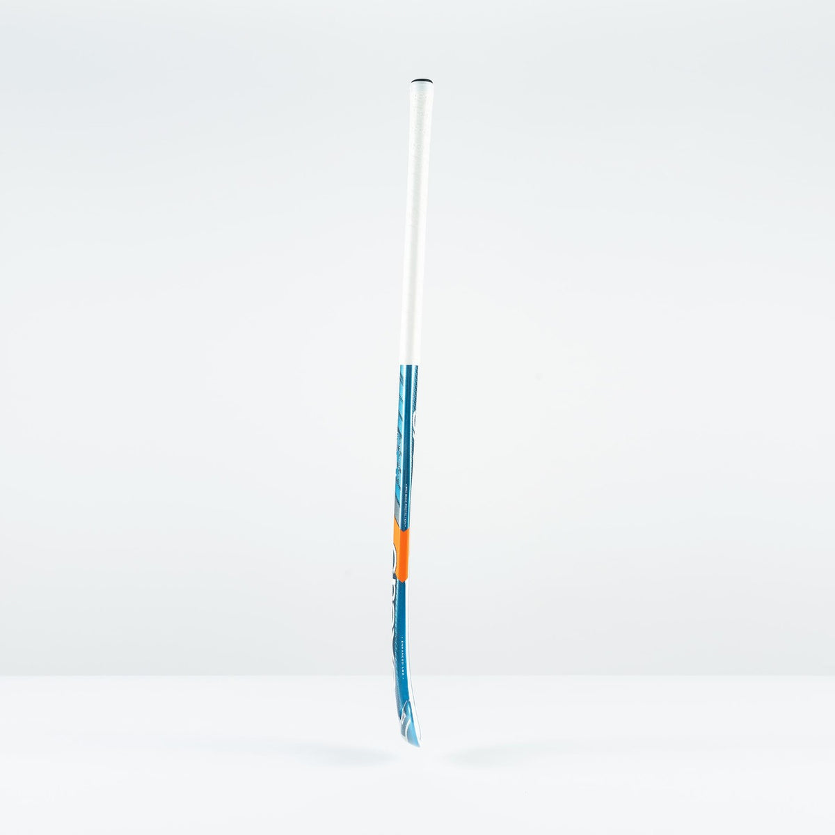 The Grays JB 7+ Junior Hockey Stick 2026, in blue and white, featuring advanced Graphene for improved drag-flicking control, stands upright on a plain white surface against a light gray background.