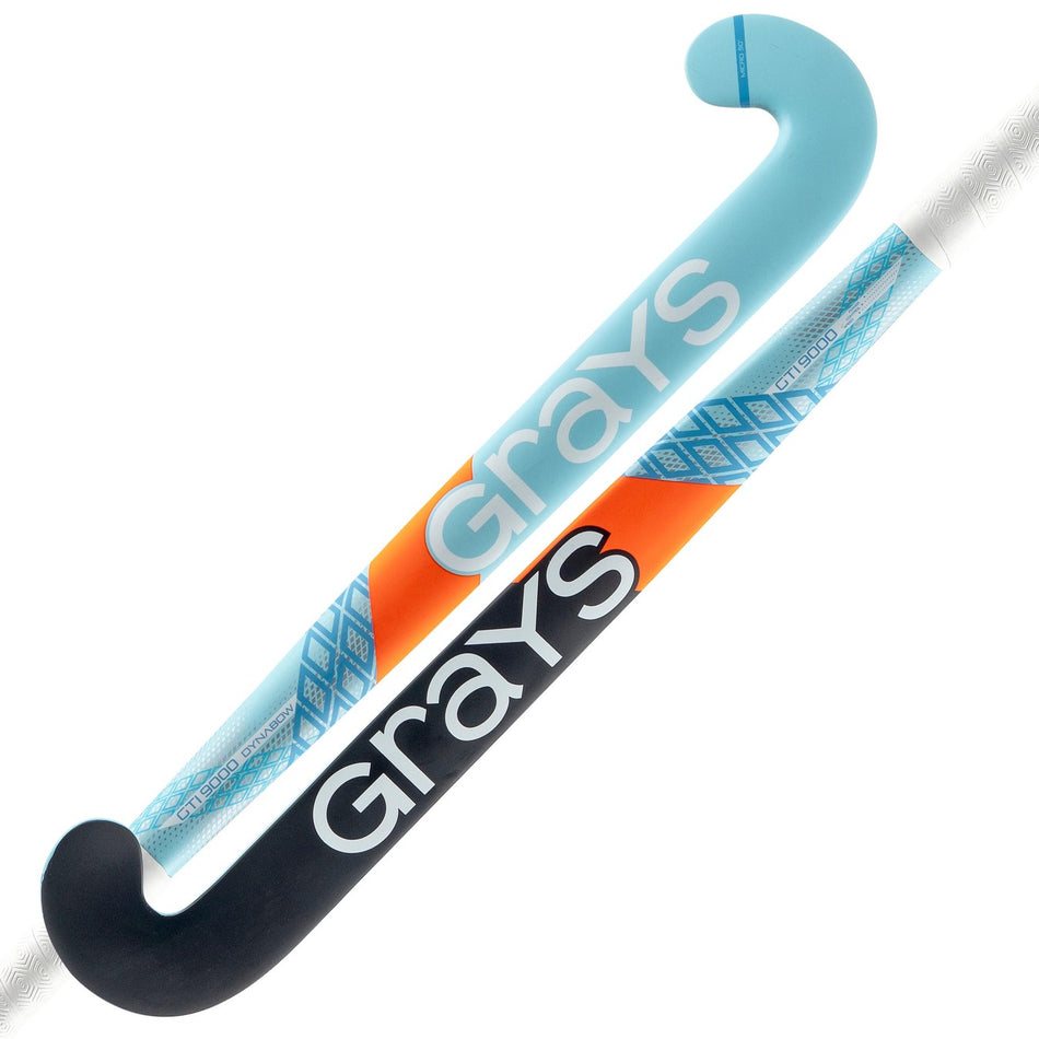 Two Grays indoor hockey sticks cross: one is black with orange and blue accents, the other is a light blue Grays GTI9000 Dynabow featuring a geometric pattern. Both display "Grays" in large white letters.