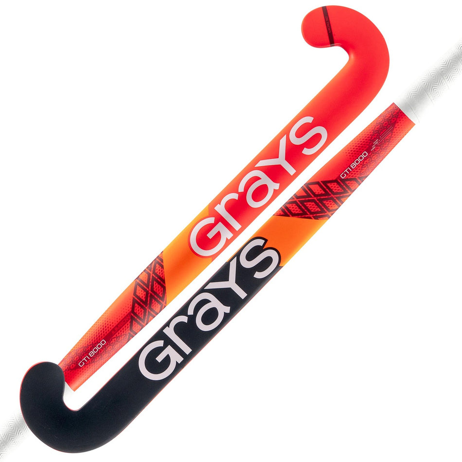 Two Grays GTI8000 Jumbow indoor hockey sticks, one facing up and one down. Both feature bold red, orange, and black designs with "Grays" in large white letters.