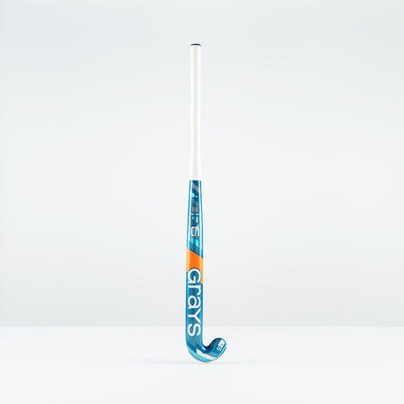 The Grays JB 6 Junior Hockey Stick 2026, in blue, white, and orange, designed for drag-flicking, stands upright against a plain white background.