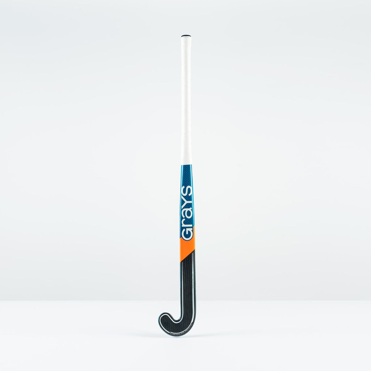The Grays JB 6 Junior Hockey Stick 2026, featuring a white handle with blue and orange accents and "Grays" printed vertically on the shaft, stands upright against a plain white background.