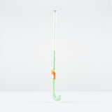 The Grays JB 5 Junior Hockey Stick 2026, featuring green and white colors with an orange band and a Jumbow blade for drag-flicking, stands upright against a plain white background.