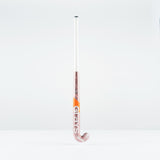 The Grays JB 4 Junior Hockey Stick 2026 features a white handle with pink and orange accents and the Grays logo on the lower part. Designed for drag-flicking, it stands upright against a plain white background.