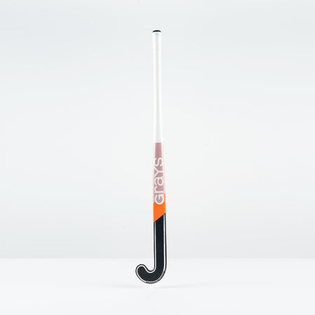 The Grays JB 4 Junior Hockey Stick 2026, featuring a white handle, orange and pink Grays branding, and a black curved end for drag-flicking, stands upright against a plain white background.