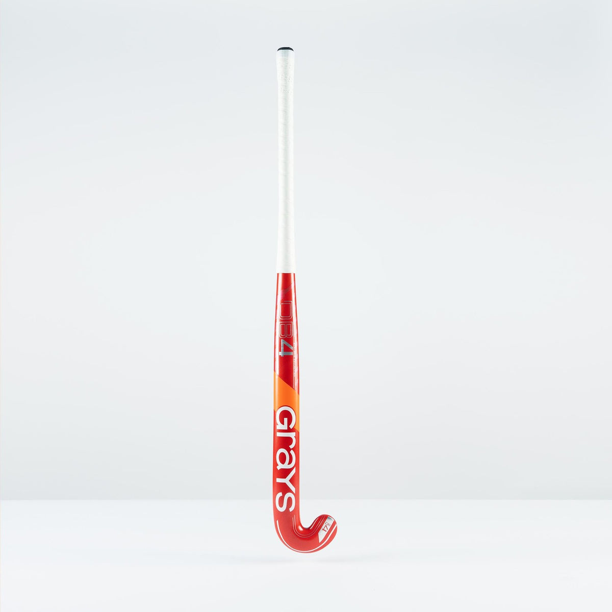The Grays DB 4 Junior Hockey Stick 2026 features a red and orange design, Dynabow blade profile, white grip, and large Grays branding—standing upright on a plain white background for enhanced 3D skill execution.