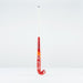 The Grays DB 4 Junior Hockey Stick 2026 features a red and orange design, Dynabow blade profile, white grip, and large Grays branding—standing upright on a plain white background for enhanced 3D skill execution.