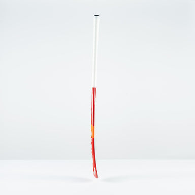 The Grays DB 4 Junior Hockey Stick 2026, in red and white with a Dynabow blade profile, stands upright on a plain white surface against a light gray background, designed by Grays for enhanced 3D skill execution.