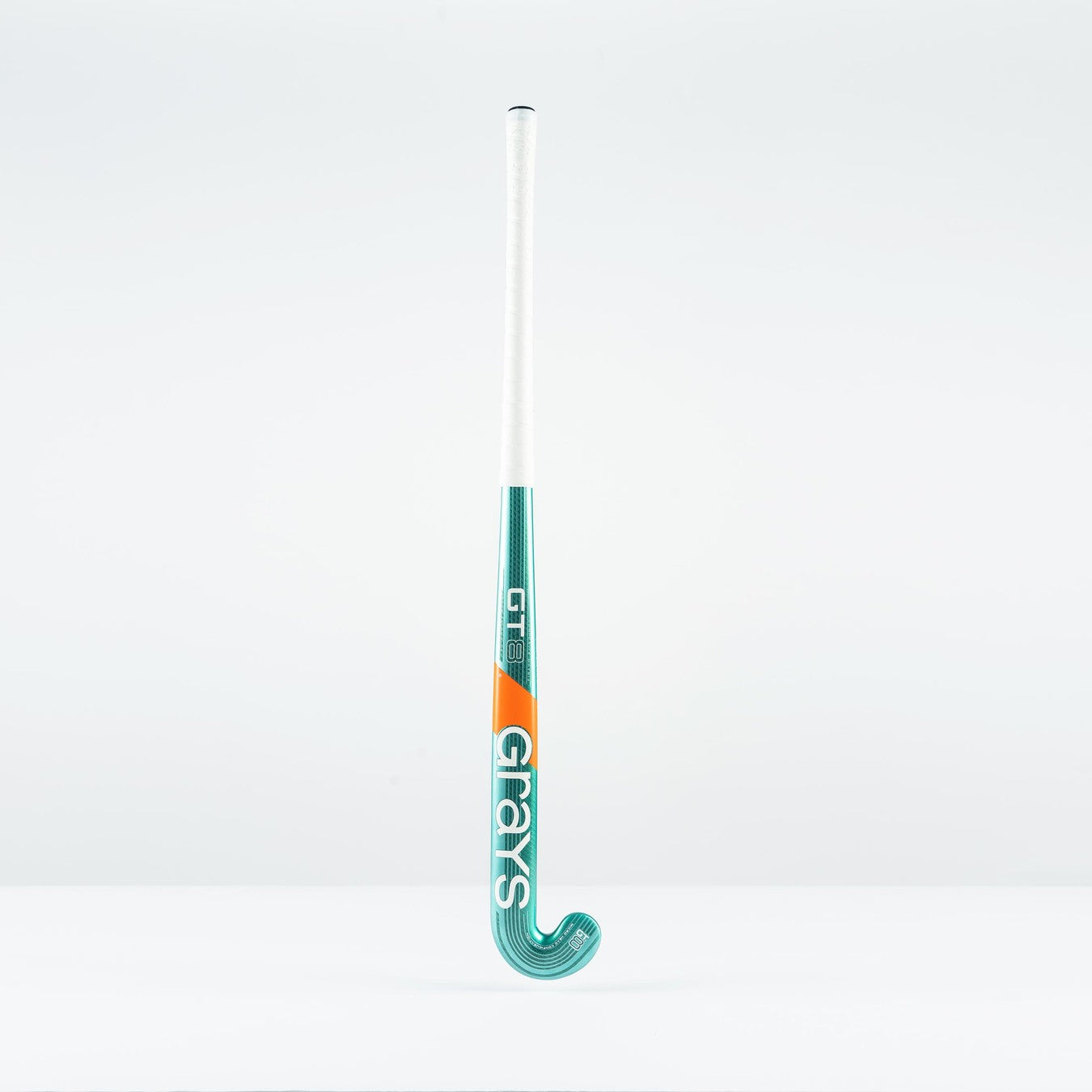 The Grays GT 8 Senior Hockey Stick 2026 stands upright against a white background, featuring teal and white colors with orange accents and aluminised-carbon construction. The brand name Grays is written vertically on the stick.