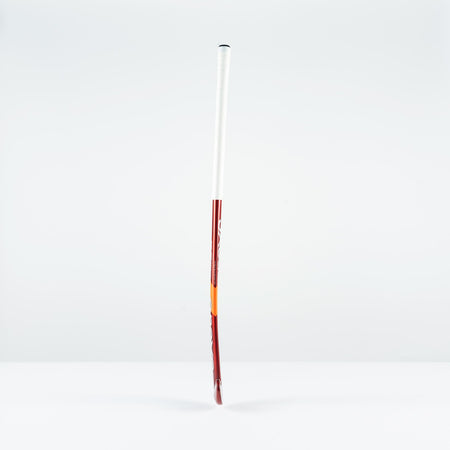 The Grays GT 5 Senior Hockey Stick 2026, in red and white with a high bow apex, stands upright on a white surface, providing intermediate power and control against a plain light gray background.