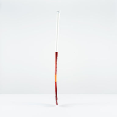 The Grays GT 5 Senior Hockey Stick 2026, in red and white with a high bow apex, stands upright on a white surface, providing intermediate power and control against a plain light gray background.