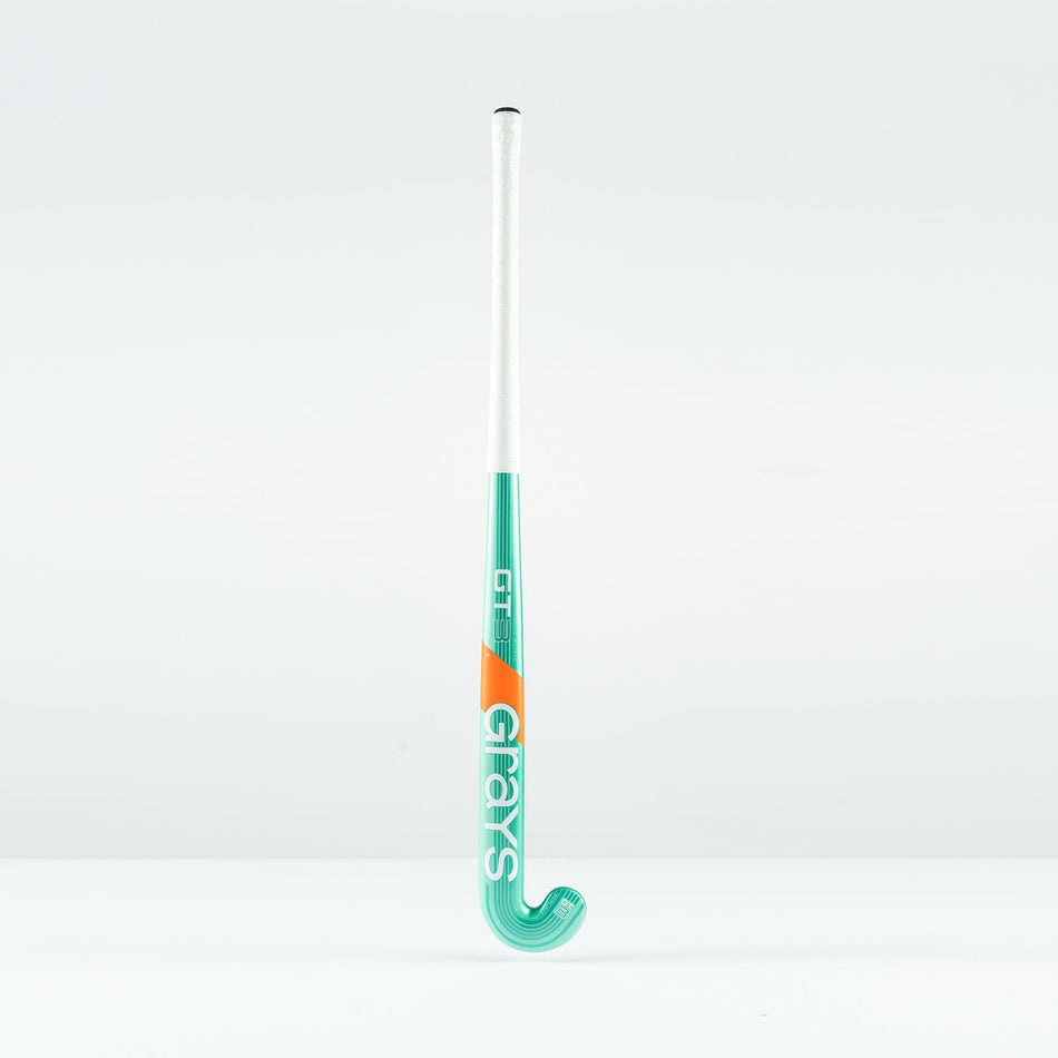 The Grays GT 3 Junior Hockey Stick 2026, in mint with orange and white accents, stands upright against a plain white background. Designed for all-round performance, it offers moderate power and control.