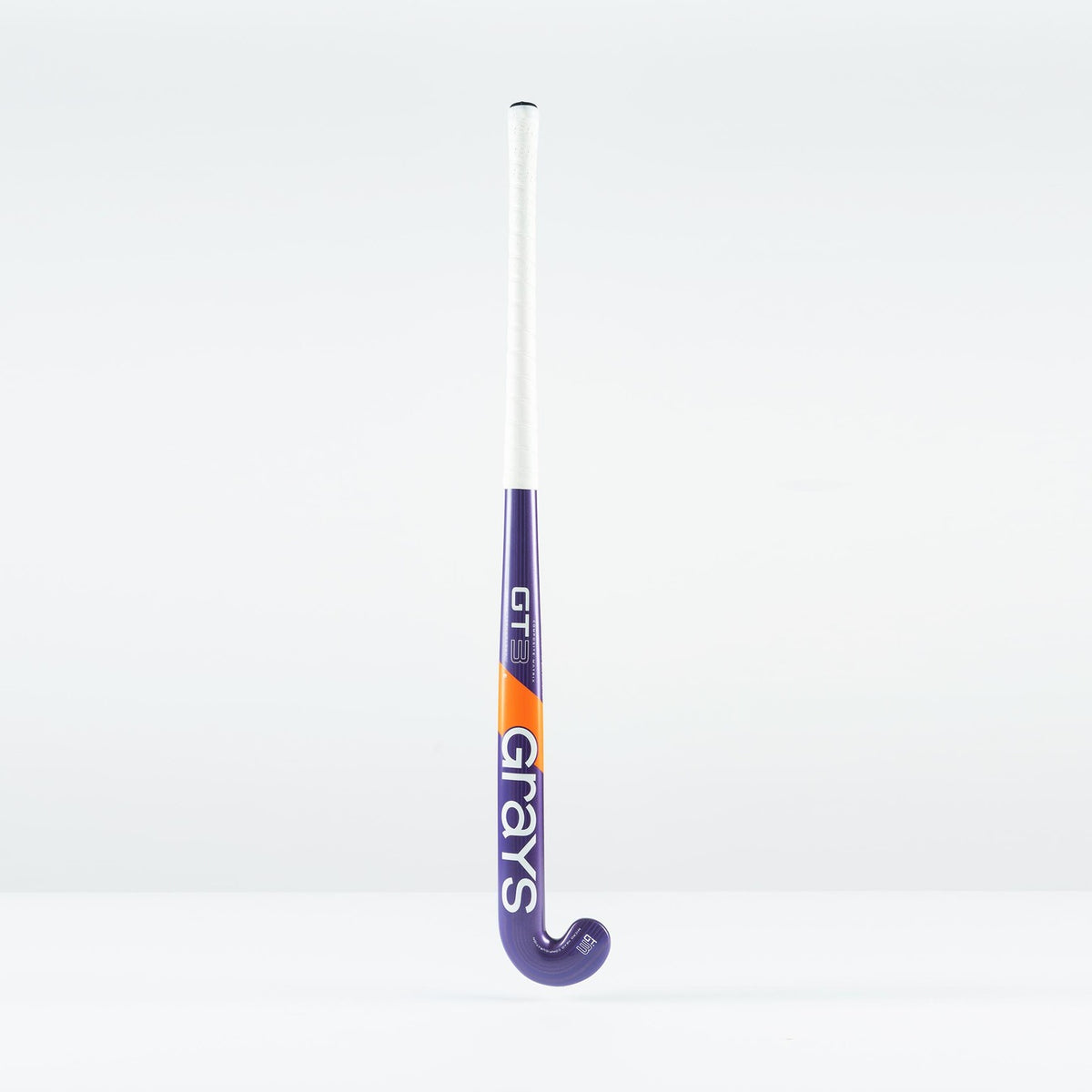 The Grays GT 3 Junior Hockey Stick 2026, in purple with a white grip and orange accents, displays the Grays brand on the shaft. Designed for balanced power and control, it stands upright against a plain white background.