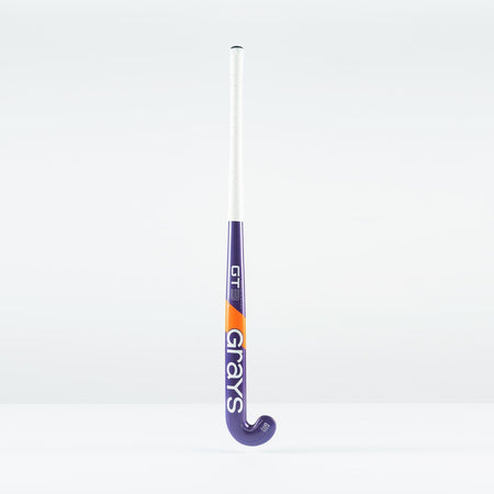 The Grays GT 3 Junior Hockey Stick 2026, in purple with a white grip and orange accents, displays the Grays brand on the shaft. Designed for balanced power and control, it stands upright against a plain white background.