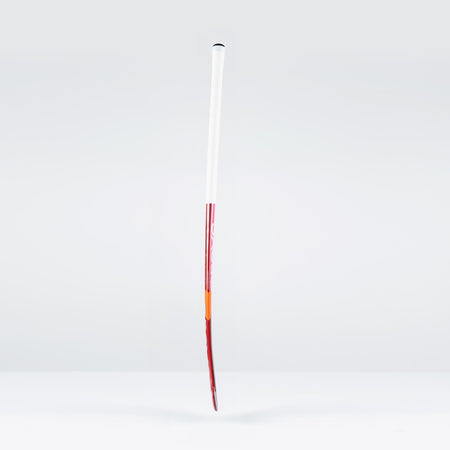 The Grays DB7Xi Dynabow Indoor Senior Hockey Stick 2026 stands upright against a light gray background, showcasing its white grip, red shaft, and orange tip—its sleek design reflecting the all-round skills of the renowned Dynabow blade.