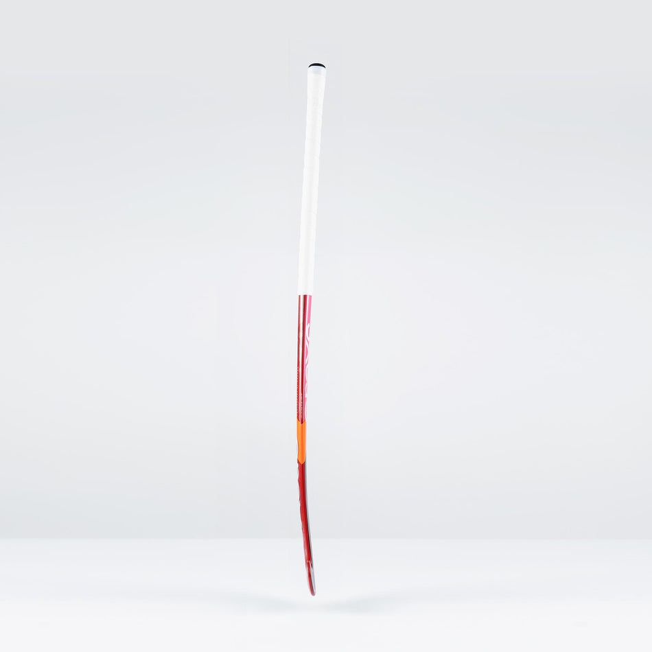 The Grays DB7Xi Dynabow Indoor Senior Hockey Stick 2026 stands upright against a light gray background, showcasing its white grip, red shaft, and orange tip—its sleek design reflecting the all-round skills of the renowned Dynabow blade.