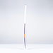 A Grays DB5Xi Dynabow Indoor Senior Hockey Stick 2026 stands upright on a white surface against a light gray background, its shaft visibly bent and lower frame damaged, resembling a well-used stick after intense all-round play.