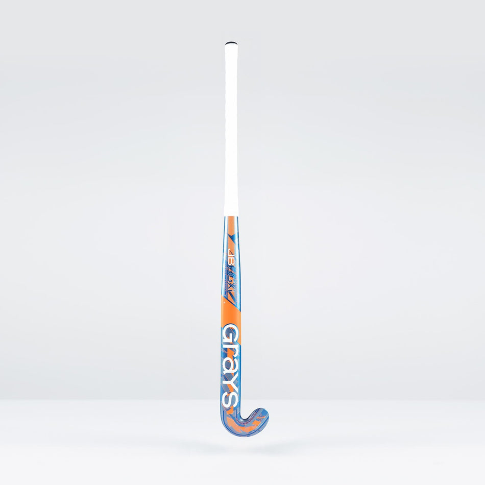 The Grays JB6GXi Jumbow Indoor Senior Hockey Stick stands upright against a plain light background, displaying its white handle and orange-blue shaft with bold GRAYS branding, designed for effective drag flicking.