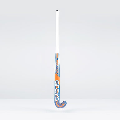 The Grays JB6GXi Jumbow Indoor Senior Hockey Stick stands upright against a plain light background, displaying its white handle and orange-blue shaft with bold GRAYS branding, designed for effective drag flicking.