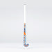 The Grays JB6GXi Jumbow Indoor Senior Hockey Stick stands upright against a plain light background, displaying its white handle and orange-blue shaft with bold GRAYS branding, designed for effective drag flicking.