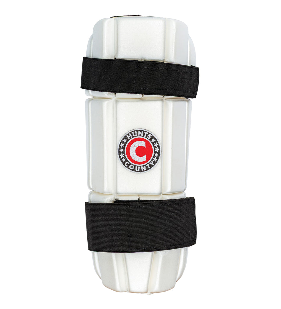 The Hunts County Triumph Arm Guard is a white batting arm guard with moulded protection, black straps, and a central Hunts County logo, designed to safeguard your arm during cricket play.