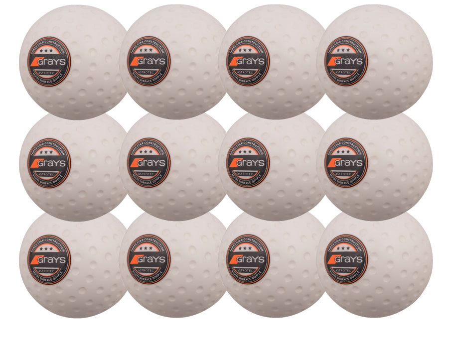 The Grays Astrotec 12 Ball Pack by Grays features twelve white dimpled hockey balls with orange-black logos, arranged in a 4x3 grid on a white background, ideal for synthetic pitches.