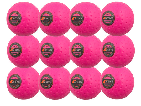 The Grays Astrotec 12 Ball Pack includes twelve bright pink dimpled PVC hockey balls for synthetic pitches, each displaying the black and orange Grays logo, neatly arranged in a 4x3 grid.
