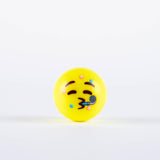 The Grays Emoji Hockey Ball by Grays features a yellow ball with a festive face, closed eyes, arched eyebrows, and pursed lips blowing a party horn with confetti—perfect as a 2025 hockey player gift—on a white background.