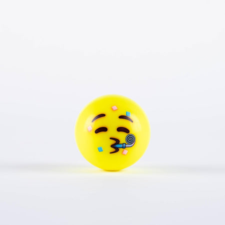 The Grays Emoji Hockey Ball by Grays features a yellow ball with a festive face, closed eyes, arched eyebrows, and pursed lips blowing a party horn with confetti—perfect as a 2025 hockey player gift—on a white background.