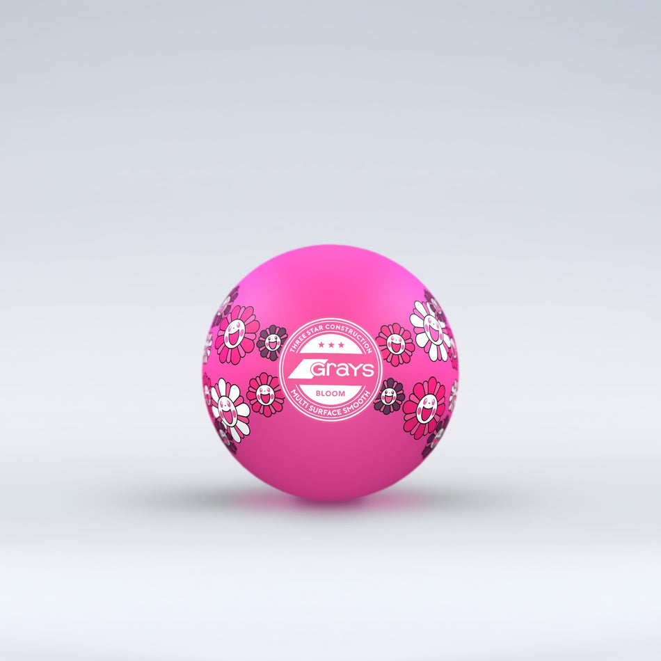 The Grays Novelty Hockey Ball 2026 features pink coloring with floral patterns, a central white Grays logo, and 3 star construction—perfect for hockey players. The ball sits against a light gray gradient background.
