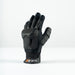 The Grays Prime Full Hockey Glove, in black with FlexShell armour and reinforced padding for top impact absorption on fingers and back, is displayed upright on a white surface. The wrist strap features the Grays brand name.