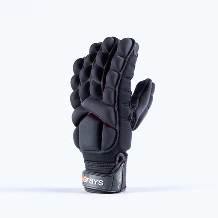The Grays Apex Full Hockey Glove in black features EVA Foam padding, protective finger and back segments, and a wrist strap with the Grays logo in red and white, shown standing upright against a plain light background.