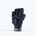 The Grays Apex Touch Hockey Glove is a black, padded half-finger sports glove with finger and knuckle protection, all-weather grip, and a wrist strap featuring the Grays brand name. Shown upright with the palm facing backward.