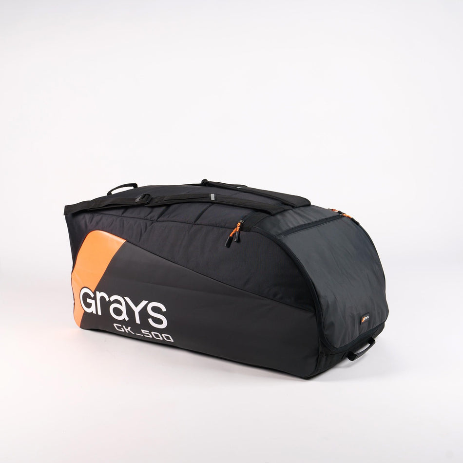 A spacious black and orange Grays GK500 Goalie Duffle by Grays, featuring multiple compartments and carrying handles, is shown on a plain white background.