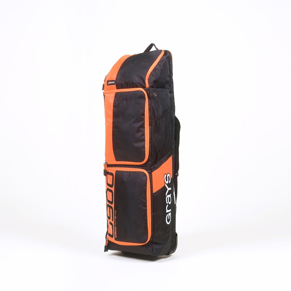 A large black and orange Grays G900 Hockey Kitbag stands upright on a white background, featuring multiple compartments, a padded stick compartment, and heavy-duty water-repellent construction.